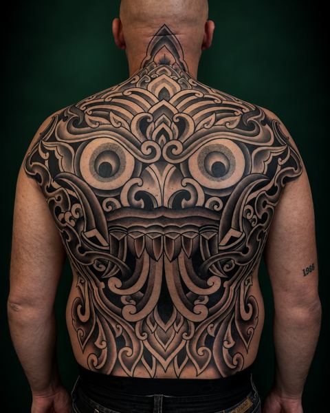 Polynesische backpiece met masker en grote ogen, gezet door Nathan bij Skin Habits Almere