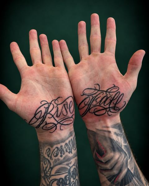 Script lettering Rise en Fall op de handpalmen, gezet door Ray bij Skin Habits Almere